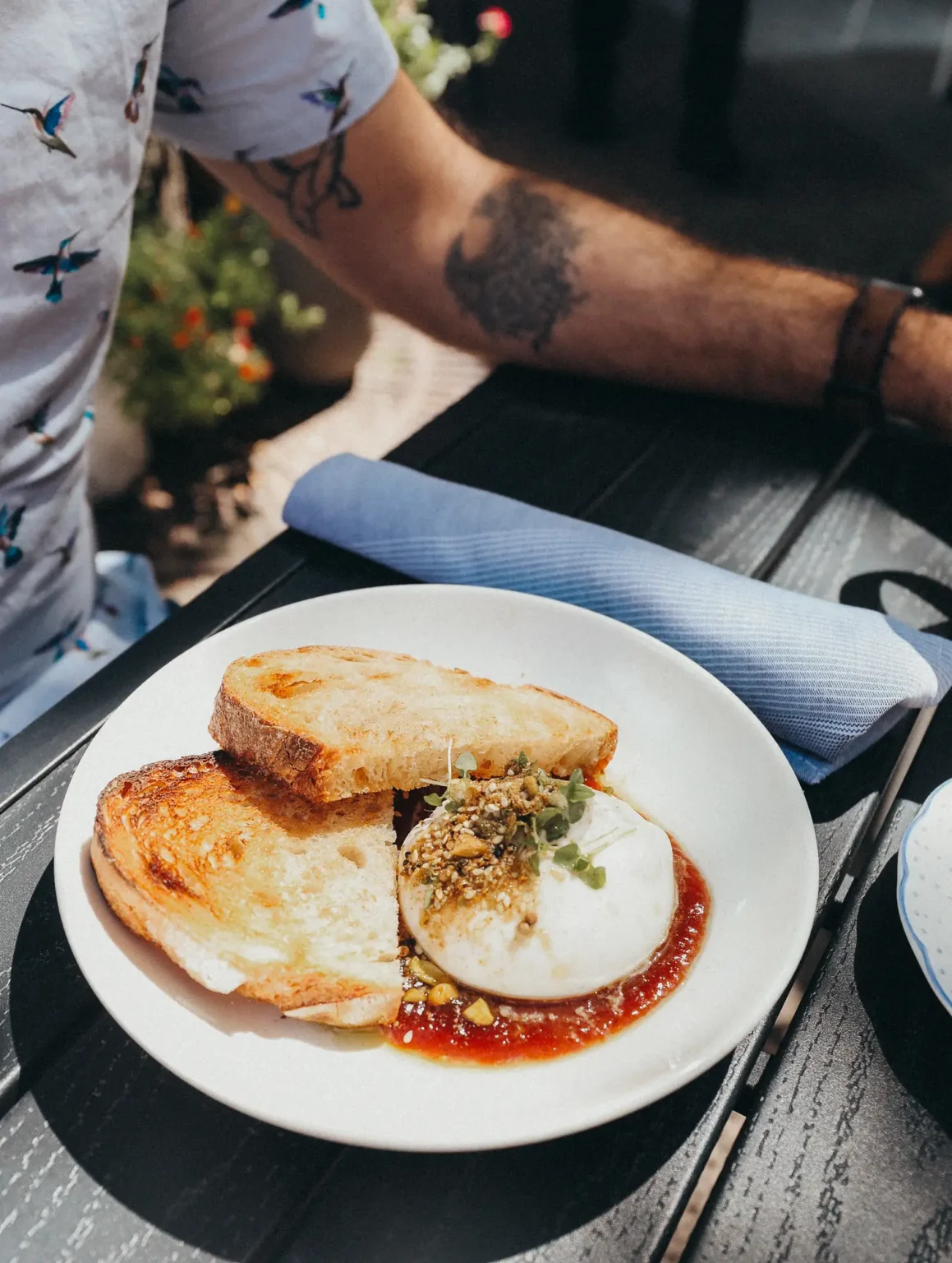 Burrata toast topped with jam and chopped pistachio